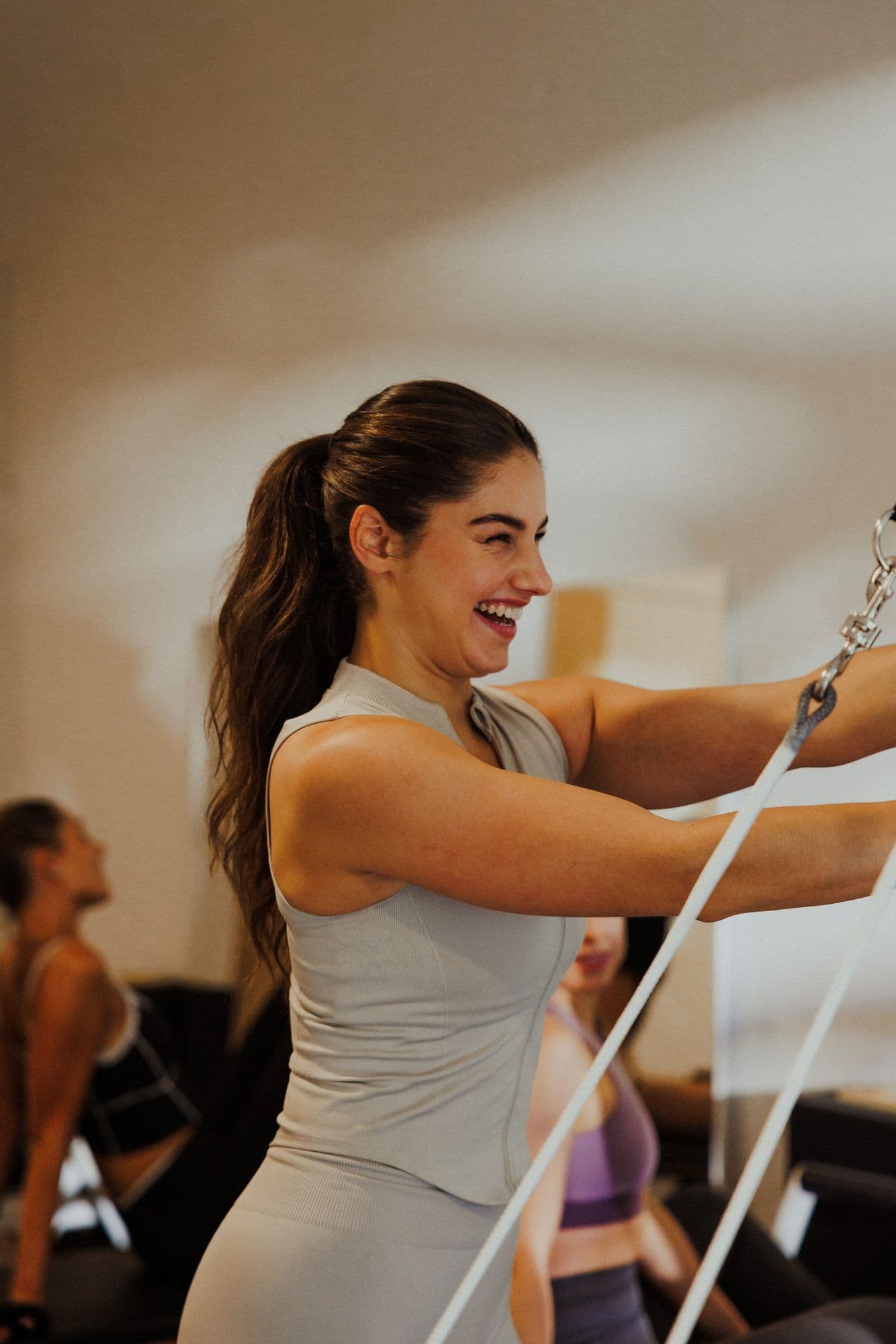 Ayleen laughing while training on the reformer